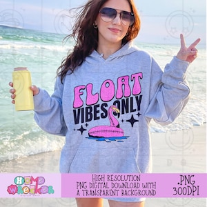 May include: A gray hoodie with a pink flamingo graphic and the text "Float Vibes Only" in pink and black letters. The hoodie is worn by a person with sunglasses and a light blue background.