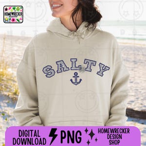 Peut inclure: Un sweat à capuche beige avec un motif bleu marine qui dit "Salty" avec une ancre en dessous. Le motif est dans une police de caractères de style universitaire.