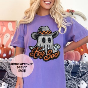 May include: Purple t-shirt with a rhinestone embellished ghost wearing a cowboy hat and the text "Hey Boo".