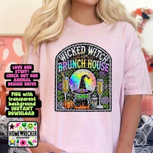 May include: A pink t-shirt with a black and rainbow graphic design featuring a witch's cauldron, pumpkins, and the text "Wicked Witch Brunch House".