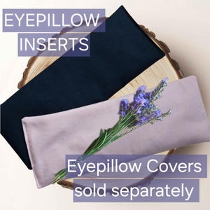 May include: Two rectangular eye pillows, one in solid black and one in solid light purple, are stacked. A sprig of dried lavender rests on the purple pillow. Text reads: EYEPILLOW INSERTS and Eyepillow Covers sold separately.