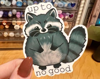 May include: A white sticker with a cartoon raccoon with the text "up to no good" on it.