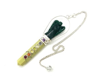 May include: A green angel carved crystal pendulum with a silver chain and a clear crystal at the end. The pendulum has seven chakra stones embedded in the shaft.