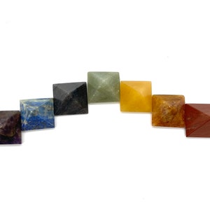 May include: Seven chakra pyramid crystals in a rainbow color arrangement. The crystals are amethyst, lapis lazuli, sodalite, black obsidian, green aventurine, citrine, and red jasper.