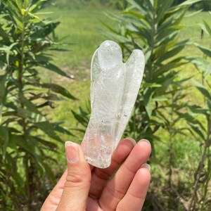 Peut inclure: Une figurine d'ange en cristal de quartz clair sculpt&eacute; dans un cristal naturel. L'ange est debout, les ailes d&eacute;ploy&eacute;es.
