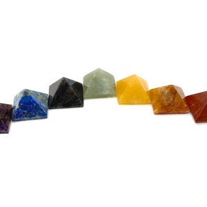 May include: Seven chakra crystal pyramids in a rainbow color arrangement. The pyramids are made of amethyst, lapis lazuli, black obsidian, green aventurine, citrine, carnelian, and red jasper.