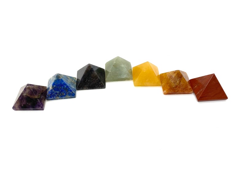 May include: Seven chakra crystal pyramids in a rainbow color arrangement. The pyramids are made of amethyst, lapis lazuli, black obsidian, green aventurine, citrine, carnelian, and red jasper.