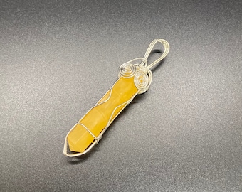 May include: A yellow crystal pendant wrapped in silver wire with a swirl design.