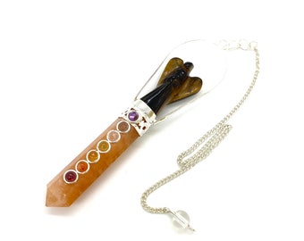 May include: A crystal pendulum with a clear quartz point, a silver chain, and a tiger's eye angel charm. The pendulum is adorned with seven chakra stones.