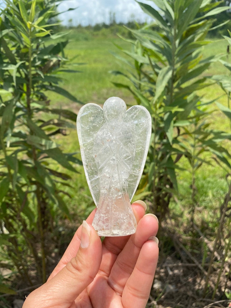 Peut inclure: Une figurine d'ange en quartz clair avec un design d&eacute;taill&eacute;. L'ange est sculpt&eacute; dans une seule pi&egrave;ce de cristal et a une finition lisse et polie.