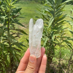 Peut inclure: Une figurine d'ange en cristal transparent avec une texture brute et naturelle. L'ange est debout, les ailes d&eacute;ploy&eacute;es.
