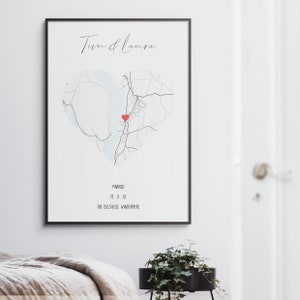 May include: A black and white map of a heart shape with a red heart in the center. The text "Tim & Laura" is at the top of the map. The text "Married 19.11.18 The Belfield, Windermere" is at the bottom of the map.