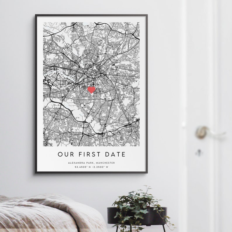 K&ouml;nnte beinhalten: Schwarz-wei&szlig;-Kartendruck mit einem roten Herzen, das den Standort von Alexandra Park, Manchester, UK markiert. Der Text "Our First Date" ist unter der Karte mit den Koordinaten 53.4505&deg; N - 2.2500&deg; W gedruckt.