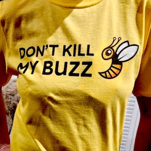 May include: Yellow t-shirt with black text that reads "Don't Kill My Buzz" and a cartoon bee with black and yellow stripes.