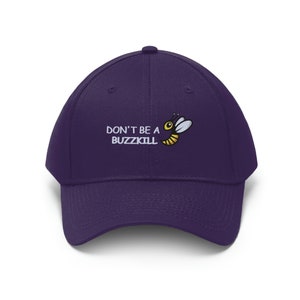 May include: Purple baseball cap with a white embroidered bee and the text "DON'T BE A BUZZKILL" in white.