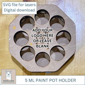May include: A laser-cut wooden paint pot holder with eight circular openings. Text on the holder reads "ADD YOUR LOGO HERE OR LEAVE BLANK" and "5 ML PAINT POT HOLDER". The top left corner has the text "SVG file for lasers Digital download".