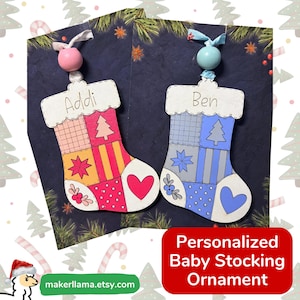 May include: Two wooden stocking ornaments with patchwork designs. The left ornament is pink and orange with the name Addi and a pink bead. The right ornament is blue and grey with the name Ben and a light blue bead. Both feature heart and tree motifs.