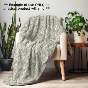 a cozy indoor setting with a white armchair, a potted plant, and a woven blanket draped over the armrest.