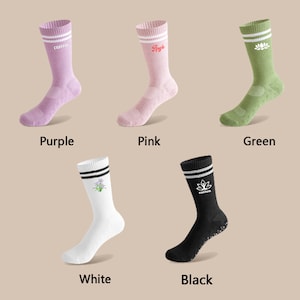 May include: Six pairs of socks in different colours, including purple, pink, green, white, and black. Each pair has a different design, including a flower, a lotus flower, and the word "custom".