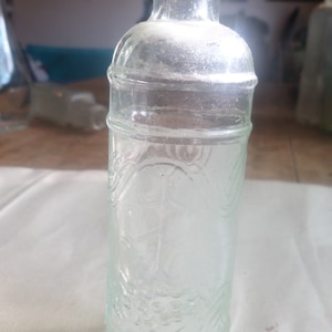Small vintage glass bottle with embossed grape vine,5 inches tall