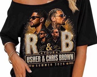 May include: A black t-shirt featuring a graphic print of Usher and Chris Brown. The design includes the text R & B, TOUR, USHER & CHRIS BROWN, and SUMMER 2026. The letters R and B are styled with a gold, diamond-like texture, and the artists are shown wearing sunglasses.