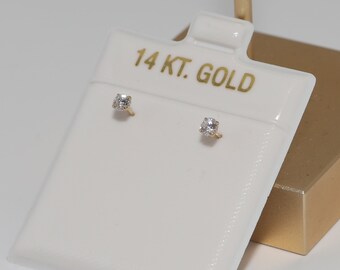 May include: A pair of small, round, clear gemstone earrings on a white card with the text "14 KT. GOLD".