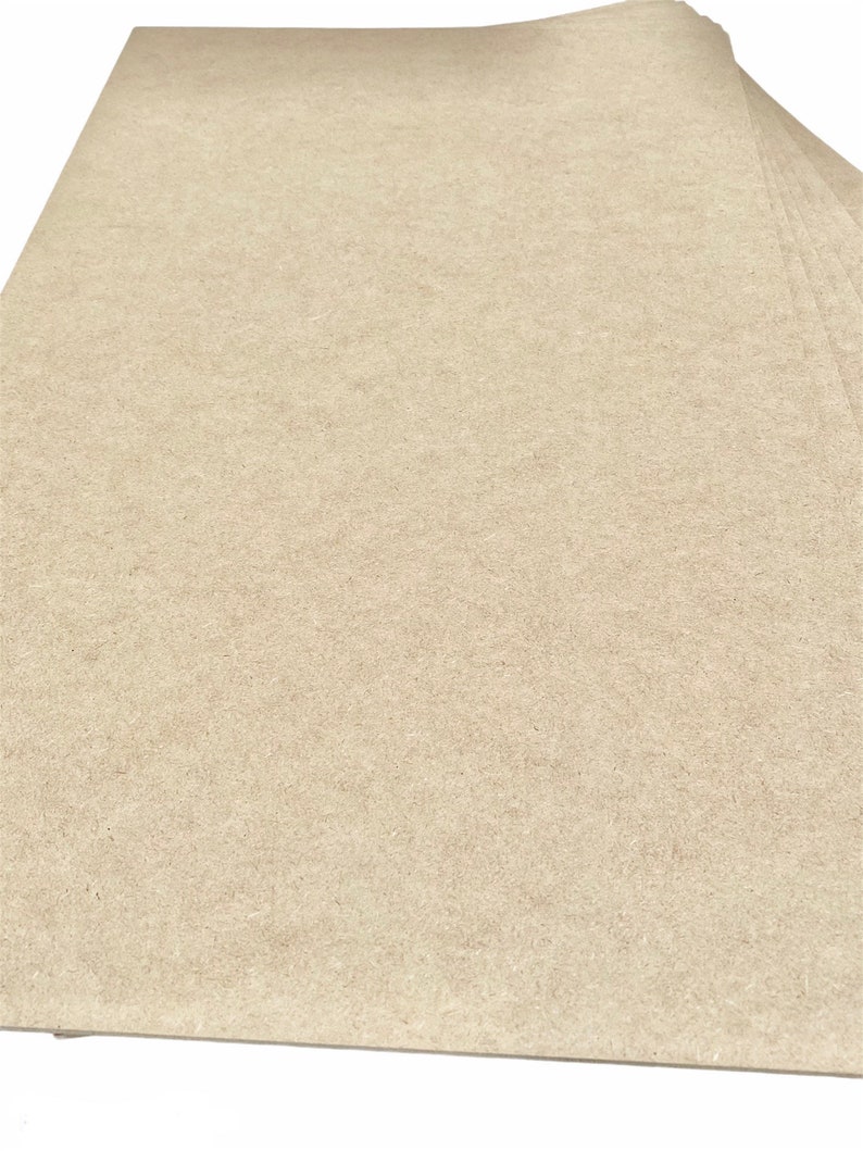 K&ouml;nnte beinhalten: Ein Stapel beigefarbener Bastelpapierb&ouml;gen. Das Papier hat eine leicht raue Textur.
