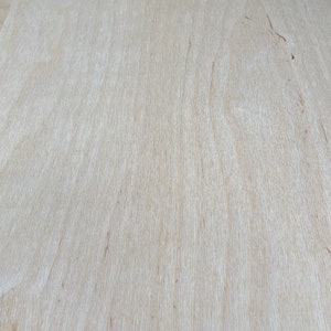 K&ouml;nnte beinhalten: Nahaufnahme einer hellbraunen Holzoberfl&auml;che mit einer glatten, gleichm&auml;&szlig;igen Textur. Das Holz hat eine nat&uuml;rliche Maserung und einen leicht warmen Ton.