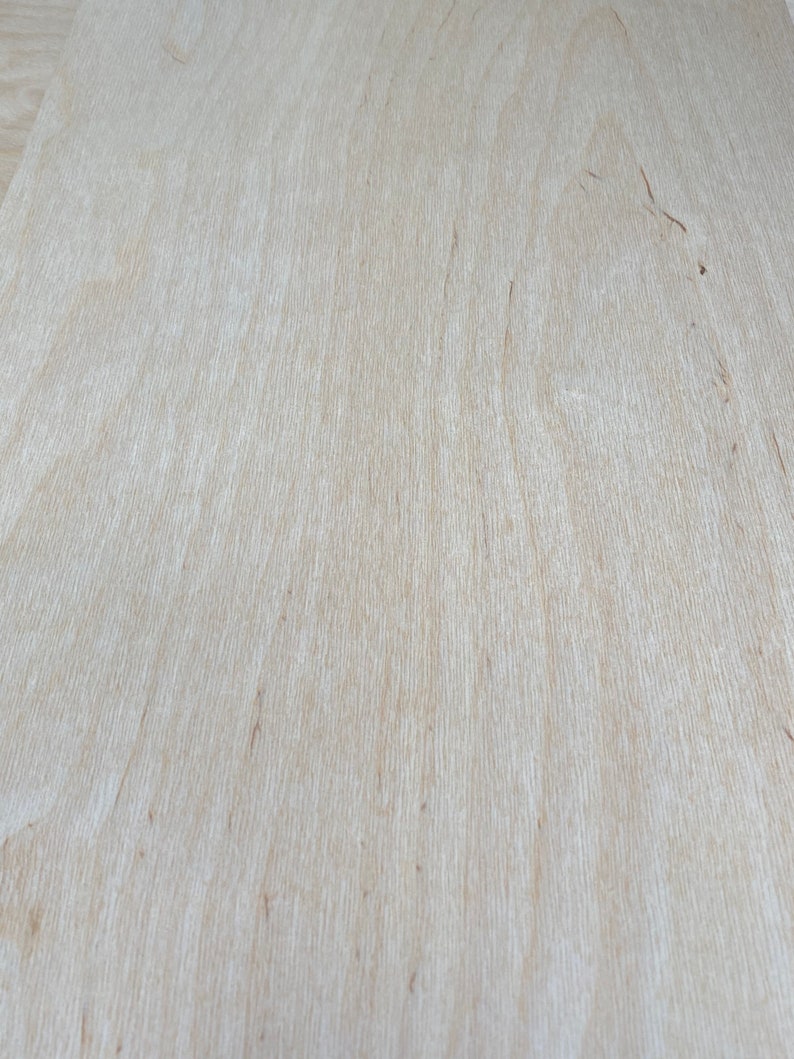 K&ouml;nnte beinhalten: Nahaufnahme einer hellbraunen Holzoberfl&auml;che mit einer glatten, gleichm&auml;&szlig;igen Textur. Das Holz hat eine nat&uuml;rliche Maserung und einen leicht warmen Ton.