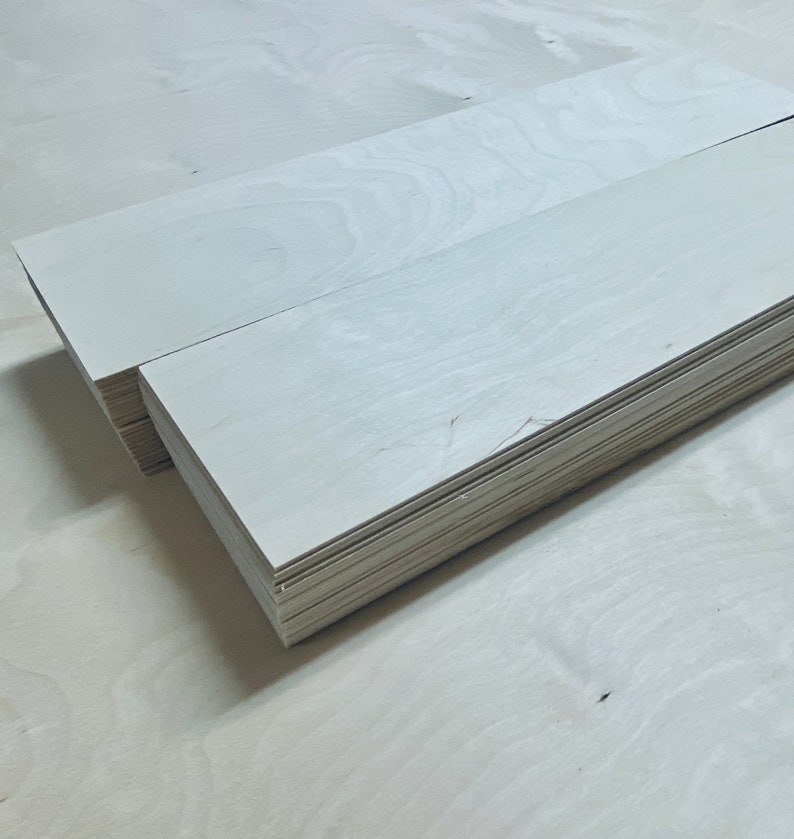 May include: A stack of white wood planks, likely for crafting or woodworking projects.