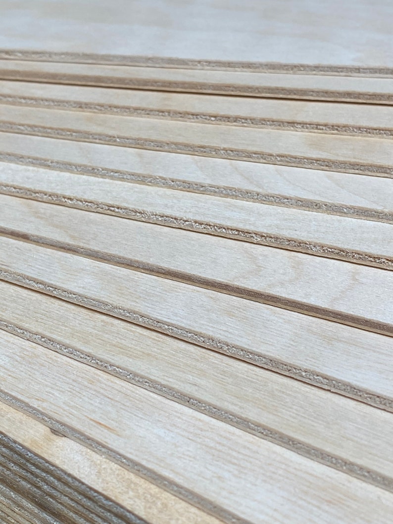 K&ouml;nnte beinhalten: Ein Stapel d&uuml;nner, heller Holzplatten mit einer glatten, nat&uuml;rlichen Oberfl&auml;che. Die Platten sind versetzt gestapelt und erzeugen so eine optische Textur.