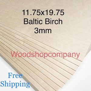 Op de afbeelding: Een stapel Baltisch berken multiplex platen. De tekst op de afbeelding luidt "11.75x19.75 Baltic Birch 3mm" en "Woodshopcompany". De platen hebben een lichte houtnerf-uitstraling.