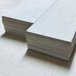 May include: A stack of light wood planks, likely for crafting or woodworking projects.