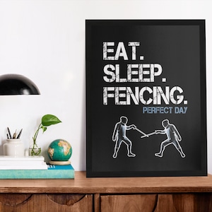 May include: Black and white framed print with the text "EAT. SLEEP. FENCING. PERFECT DAY" and two stick figures fencing.