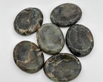 May include: Six oval-shaped labradorite palm stones in shades of gray, black, and green. The stones are smooth and polished.
