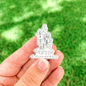May include: A clear sticker with a black line drawing of a house with the text "It's not much, but it's home".
