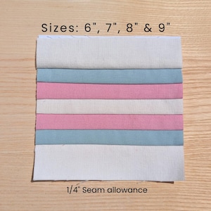 May include: A fabric swatch with alternating stripes of white, light blue, and pink. The text "Sizes: 6", 7", 8" & 9"" is at the top, and "1/4" Seam allowance" is at the bottom. The fabric is on a wooden surface.