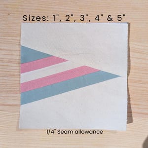 May include: A square fabric piece with a white background and a diagonal design in pink and blue. The text "Sizes: 1", 2", 3", 4" & 5"" and "1/4" Seam allowance" are printed on the fabric.