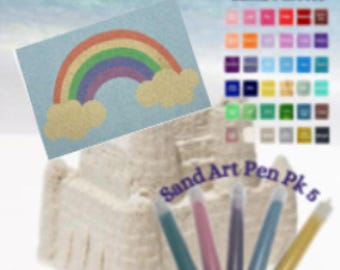 May include: A sandcastle with a rainbow drawing and a set of five sand art pens. The rainbow is multi-colored with yellow clouds. The sand art pens are teal, pink, purple, blue, and yellow.