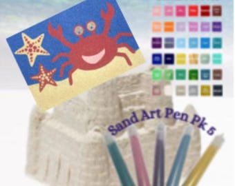 May include: A sand art kit featuring a blue background with a red crab and starfish design. The kit includes a sand castle, a sand palette, and five sand art pens. The text "Sand Art Pen Pk 5" is visible.