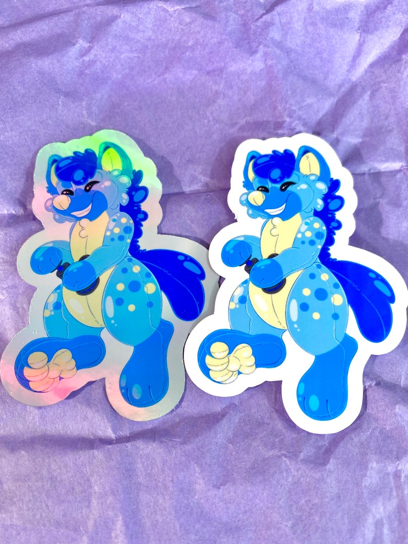 May include: Two blue and white holographic stickers of a cartoon animal with a happy expression. The animal is wearing a blue and white patterned outfit and has a blue tail.