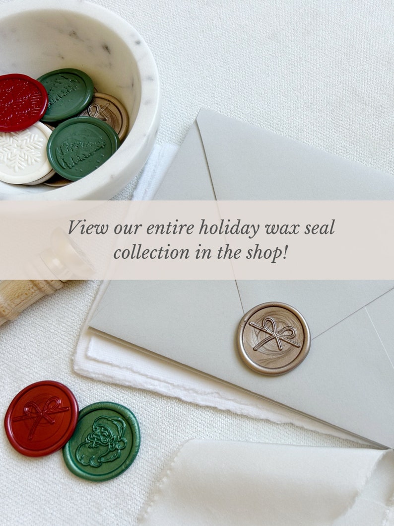 May include: A collection of holiday wax seals in a white marble bowl. The seals are in various colors, including red, green, and gold. The seals feature designs such as a snowflake, a Christmas tree, and a bow. The text "View our entire holiday wax seal collection in the shop!" is displayed on a banner above the bowl.