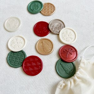 May include: Assortment of wax seals with various holiday designs, including snowflakes, Christmas trees, wreaths, and bows. The seals are in shades of red, green, gold, and white.