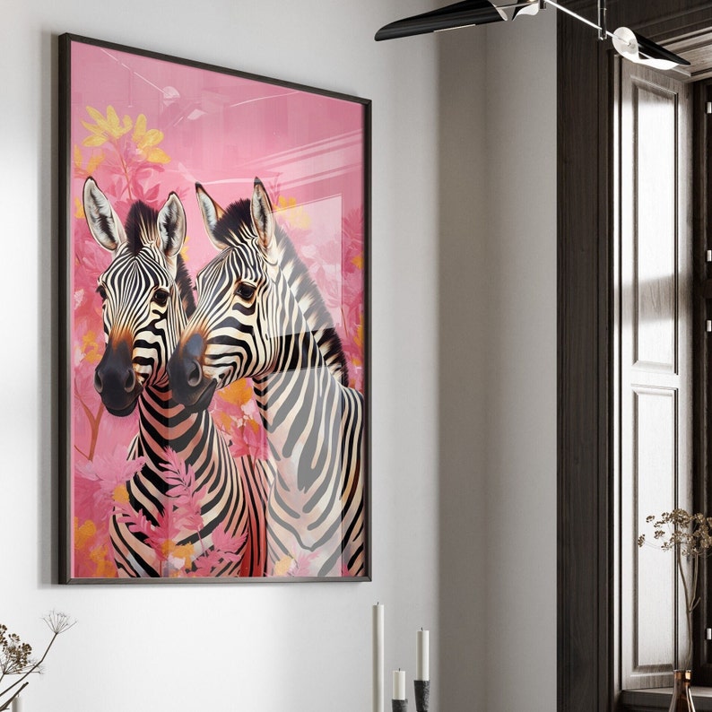 K&ouml;nnte beinhalten: Ein gerahmter Druck von zwei Zebras mit schwarzen und wei&szlig;en Streifen vor einem rosa Hintergrund mit floralen Akzenten.