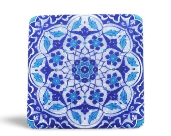 May include: A square ceramic tile with a blue and white geometric pattern. The design features a central mandala with intricate details and floral motifs.