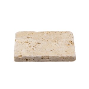 May include: A rectangular, beige-colored stone coaster with a textured surface. The coaster has a natural, porous appearance, and is likely made of travertine or a similar material. The edges are slightly rounded.