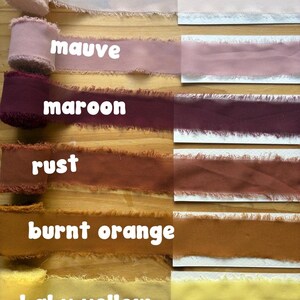 May include: A selection of fabric ribbons in various colors, including baby pink, mauve, maroon, rust, burnt orange, and baby yellow. Each ribbon has a frayed edge and is labeled with its color name in white text.