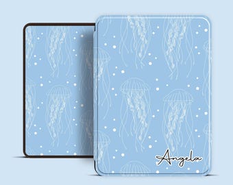 May include: A light blue case with a white jellyfish pattern and the name "Angela" in cursive. The case is shown open, revealing a black interior. The design features white jellyfish and small white dots.