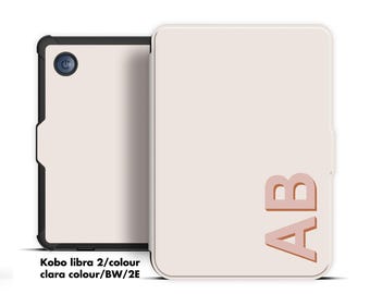 May include: A light beige Kobo Libra 2 e-reader with a matching cover. The cover features the initials "AB" in a darker beige. The e-reader is open, revealing a black frame and a power button. The text "Kobo libra 2/colour clara colour/BW/2E" is visible.