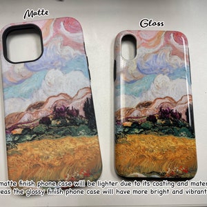 Puede incluir: Dos fundas para tel&eacute;fono con una pintura de un paisaje con un campo de trigo, colinas y un cielo nublado. La funda de la izquierda es mate y la funda de la derecha es brillante. El texto "Matte" est&aacute; encima de la funda de la izquierda y el texto "Gloss" est&aacute; encima de la funda de la derecha.